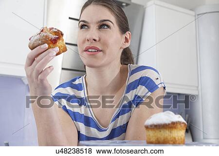Young woman holding muffin View Large Photo Image Stock Photo - Young woman holding muffin. Fotosearch