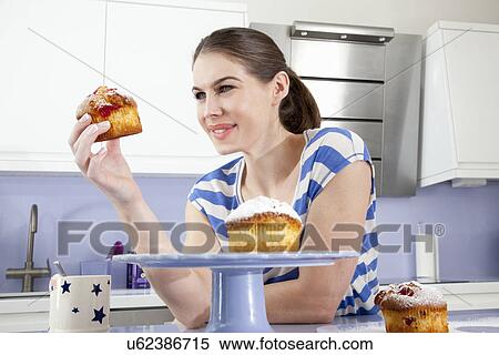 Young woman holding muffin View Large Photo Image Stock Photography - Young woman holding muffin. Fotosearch