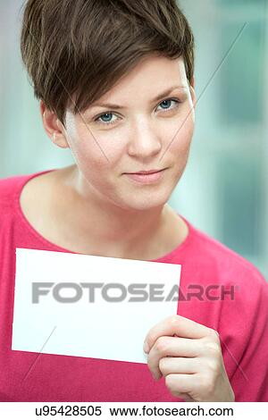 Stock Photography - Young woman holding white card. Fotosearch