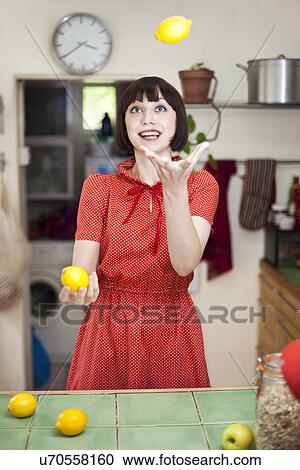 Young woman in kitchen juggling lemons View Large Photo Image Stock Image - Young woman in kitchen juggling lemons. Fotosearch