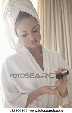 Young woman in robe with medicine bottle and pills View Large Photo Image Stock Photo - Young woman in robe with medicine bottle and pills. Fotosearch