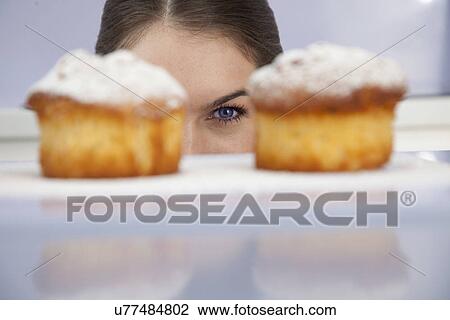 Young woman looking at freshly bakes cakes View Large Photo Image Stock Image - Young woman looking at freshly bakes cakes. Fotosearch