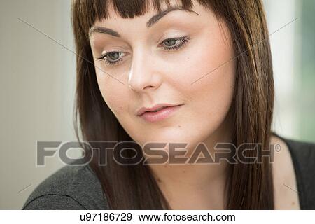 Stock Photo - Young woman looking down. Fotosearch