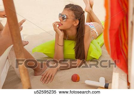 Stock Photography - Young woman lying on beach. Fotosearch