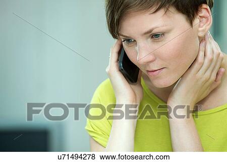 Stock Photo - Young woman on mobile phone. Fotosearch