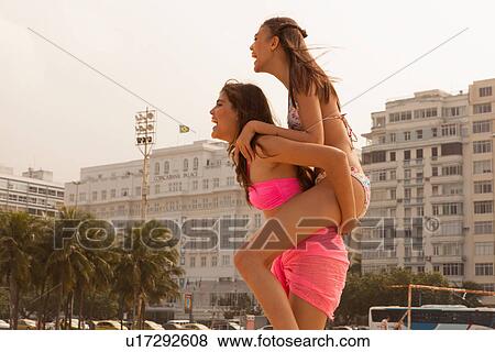 Young woman riding piggyback on friend, Copacabana Beach, Rio De Janeiro, Brazil View Large Photo Image Stock Photo - Young woman riding piggyback on friend, Copacabana Beach, Rio De Janeiro, Brazil. Fotosearch