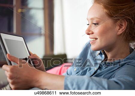 Stock Image - Young woman using digital tablet. Fotosearch