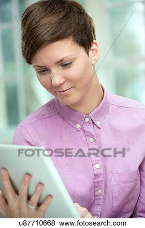 Young woman using digital tablet View Large Photo Image Stock Photo - Young woman using digital tablet. Fotosearch