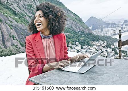 Young woman using laptop, Casa Alto Vidigal, Rio De Janeiro, Brazil View Large Photo Image Stock Image - Young woman using laptop, Casa Alto Vidigal, Rio De Janeiro, Brazil. Fotosearch