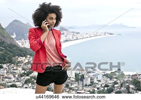Young woman using mobile phone, Casa Alto Vidigal, Rio De Janeiro, Brazil View Large Photo Image Stock Photograph - Young woman using mobile phone, Casa Alto Vidigal, Rio De Janeiro, Brazil. Fotosearch