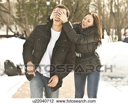 Young woman with hands covering boyfriends eyes View Large Photo Image Stock Image - Young woman with hands covering boyfriends eyes. Fotosearch
