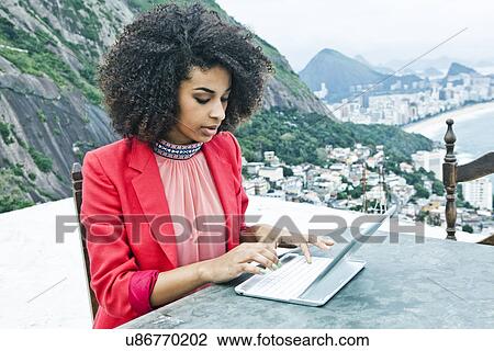 Young woman with laptop, Casa Alto Vidigal, Rio De Janeiro, Brazil View Large Photo Image Stock Image - Young woman with laptop, Casa Alto Vidigal, Rio De Janeiro, Brazil. Fotosearch
