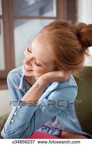 Stock Photo - Young woman with question mark tattoo smiling. Fotosearch