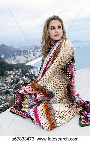 Stock Image - Young woman wrapped in wool blanket, Casa Alto Vidigal, Rio De Janeiro, Brazil. Fotosearch