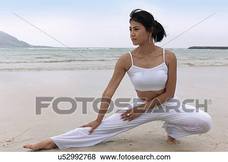 Stock Photo - Beach, Exercising, Yoga, Body Care, Body Conscious, Fitness, Asian Ethnicity. Fotosearch