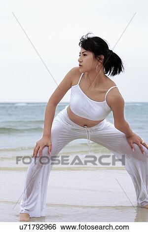 Stock Photograph - Beach, Exercising, Yoga, Body Care, Body Conscious, Fitness, Asian Ethnicity. Fotosearch