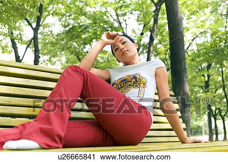Stock Image - Greenery, Young Couple, Lying Down, Leisure Activity, Young Adult, Asian Ethnicity. Fotosearch
