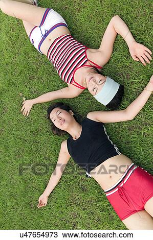 Stock Image - Greenery, Young Couple, Lying Down, Leisure Activity, Young Adult, Asian Ethnicity. Fotosearch