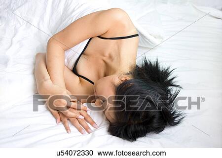 Stock Image - Greenery, Young Couple, Lying Down, Leisure Activity, Young Adult, Asian Ethnicity. Fotosearch