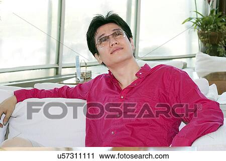 Stock Image - Greenery, Young Couple, Lying Down, Leisure Activity, Young Adult, Asian Ethnicity. Fotosearch