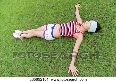 Stock Image - Greenery, Young Couple, Lying Down, Leisure Activity, Young Adult, Asian Ethnicity. Fotosearch