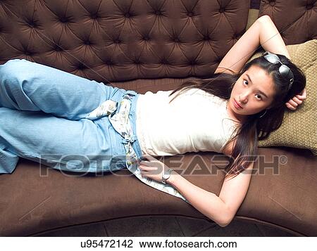 Stock Image - Greenery, Young Couple, Lying Down, Leisure Activity, Young Adult, Asian Ethnicity. Fotosearch