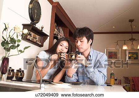 Stock Photo - Indoors, Young Adult, Young Men, Young Women, Young Couple, Togetherness, Bonding. Fotosearch