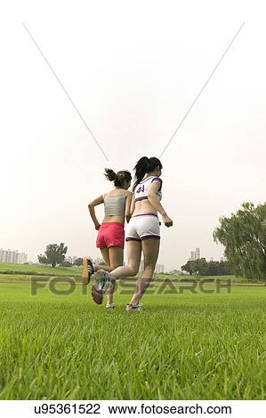 Stock Image - Young Adult, Young Men, Young Women, Outdoors, Sports Clothing, Athletic, Healthy Lifestyle. Fotosearch