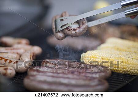 Barbecuing sausages and corn on the cob View Large Photo Image Stock Image - Barbecuing sausages and corn on the cob. Fotosearch