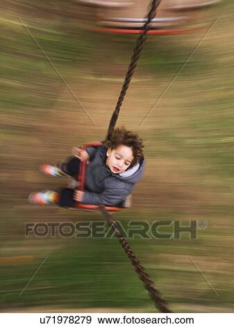 Stock Photo - Blurred image of boy on swing. Fotosearch