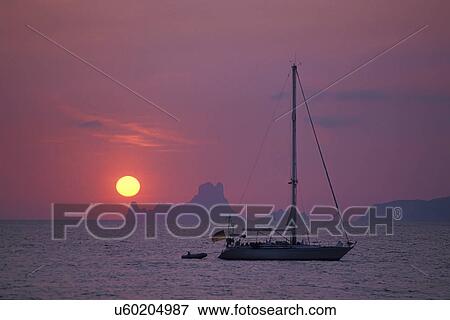 Boat at sunset against background of Es Vedra, Formentera, Balearic Islands, Spain View Large Photo Image Stock Photo - Boat at sunset against background of Es Vedra, Formentera, Balearic Islands, Spain. Fotosearch
