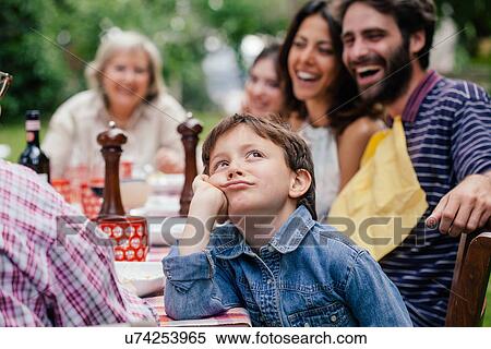 Bored boy at outdoor family meal View Large Photo Image Stock Photography - Bored boy at outdoor family meal. Fotosearch