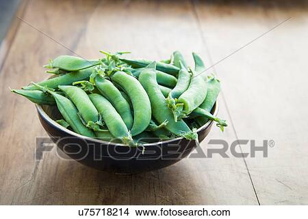 Bowl of peapods on table View Large Photo Image Picture - Bowl of peapods on table. Fotosearch
