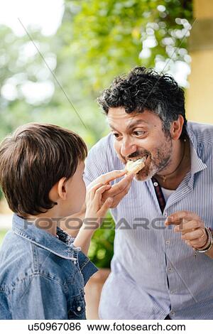 Boy and father eating bread View Large Photo Image Stock Photograph - Boy and father eating bread. Fotosearch