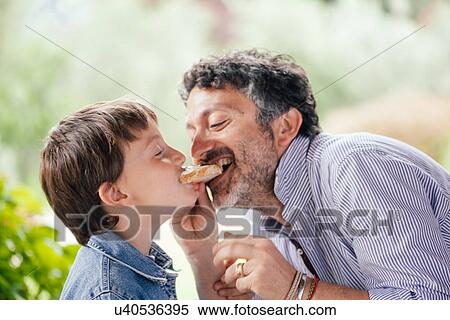 Boy and father eating same slice of bread View Large Photo Image Stock Photography - Boy and father eating same slice of bread. Fotosearch