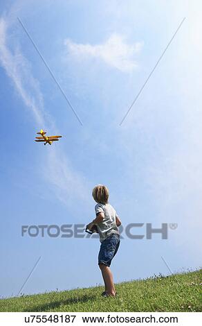 Stock Photo - Boy flying model plane. Fotosearch
