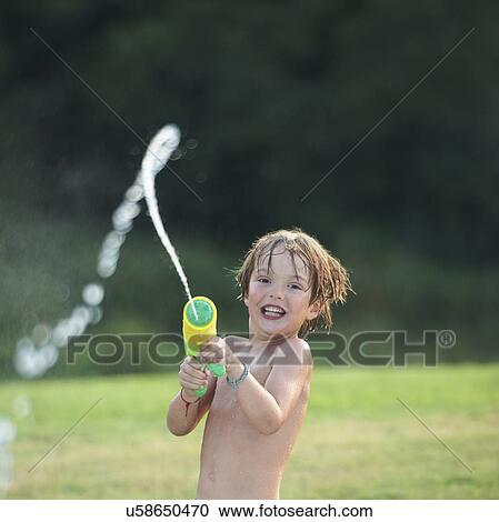 Boy having fun with water gun View Large Photo Image Stock Image - Boy having fun with water gun. Fotosearch