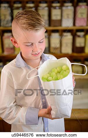 Boy holding bag of confectionery View Large Photo Image Stock Photograph - Boy holding bag of confectionery. Fotosearch