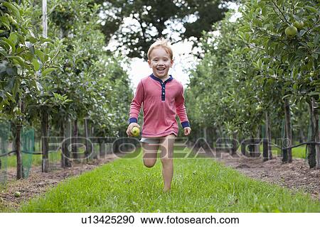 Boy running through apple orchard View Large Photo Image Stock Image - Boy running through apple orchard. Fotosearch