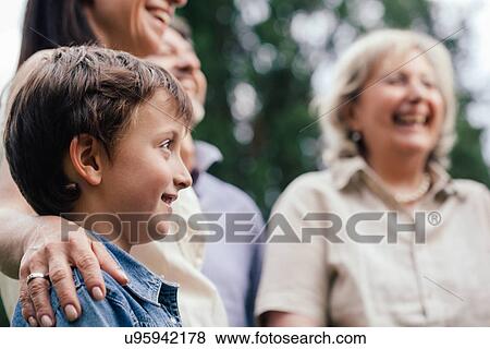 Boy surrounded by family View Large Photo Image Stock Photo - Boy surrounded by family. Fotosearch