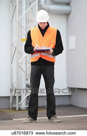 Builder writing paperwork using clipboard View Large Photo Image Stock Image - Builder writing paperwork using clipboard. Fotosearch