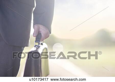 Businessman holding brief case View Large Photo Image Stock Photo - Businessman holding brief case. Fotosearch