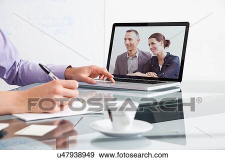 Businessman on video conference with two colleagues View Large Photo Image Stock Photo - Businessman on video conference with two colleagues. Fotosearch