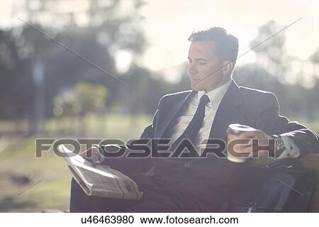 Businessman reading on park bench View Large Photo Image Stock Image - Businessman reading on park bench. Fotosearch