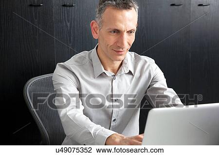 Stock Image - Businessman using laptop. Fotosearch