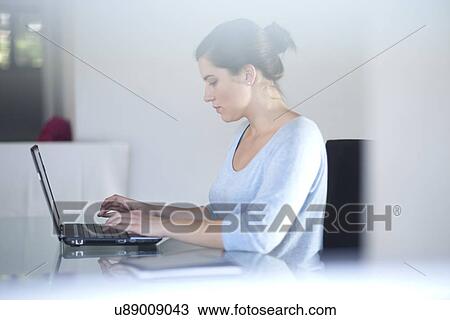 Stock Image - Businesswoman using laptop computer. Fotosearch