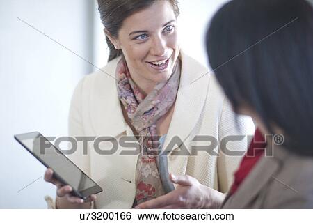 Businesswomen using digital tablet View Large Photo Image Stock Photograph - Businesswomen using digital tablet. Fotosearch