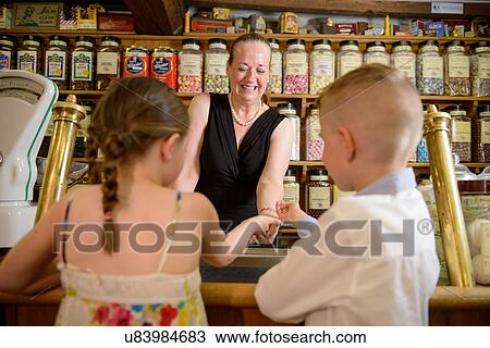 Stock Image - Children buying sweets from traditional sweet shop. Fotosearch