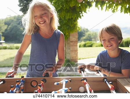Picture - Children playing foosball. Fotosearch