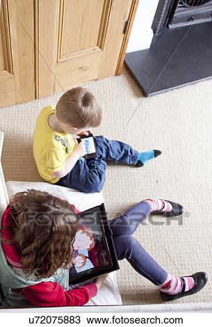 Children using digital tablet and cellular phone View Large Photo Image Stock Image - Children using digital tablet and cellular phone. Fotosearch
